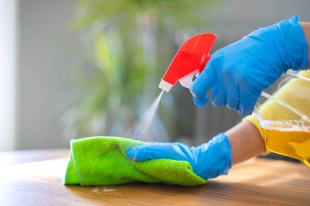 Spraying cleanser on a desk